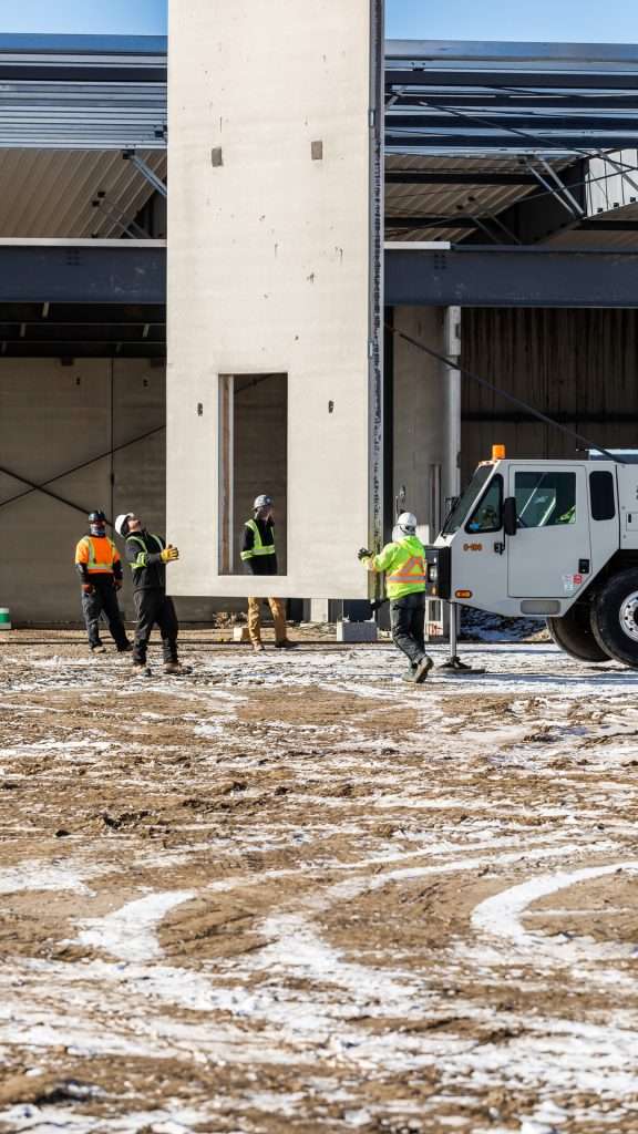 construction workers wearing their Safety ppe on a commercial construction project with snow on the ground